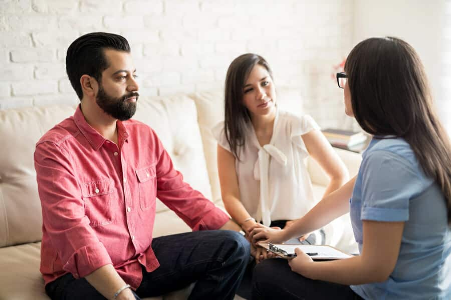 A married couple works with their counselor in family therapy.